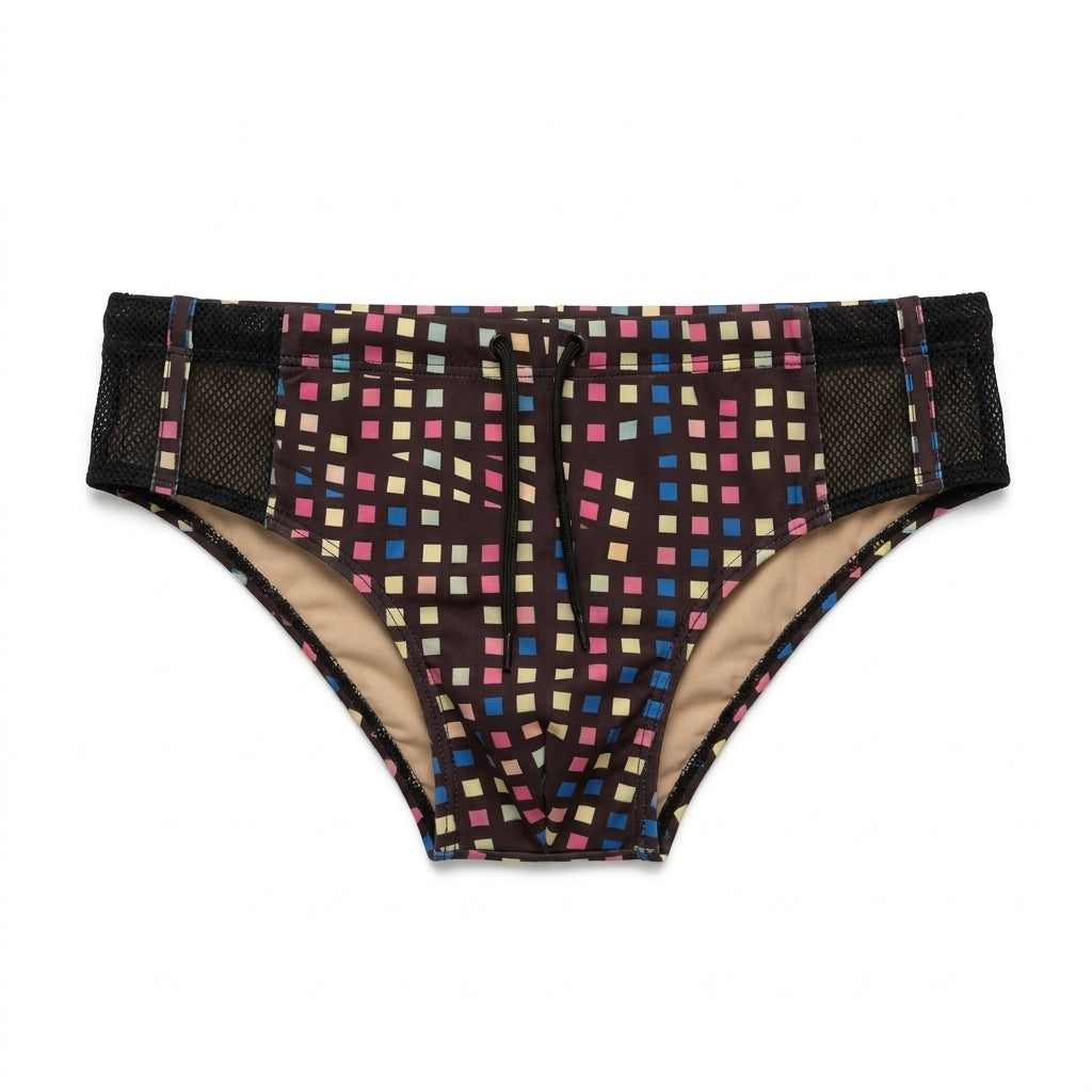 Sunga Píxel isolada de frente, em sarja com fundo marrom muito escuro e pequenos quadrados azuis, rosas e amarelo-claro, cós estampado, cordão central, forro bege nude e insertos laterais de tela preta com faixa de sarja.